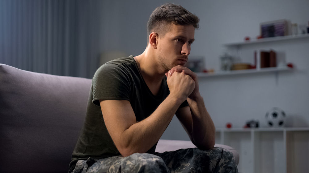 A man reflecting deeply, indicative of mental health treatment