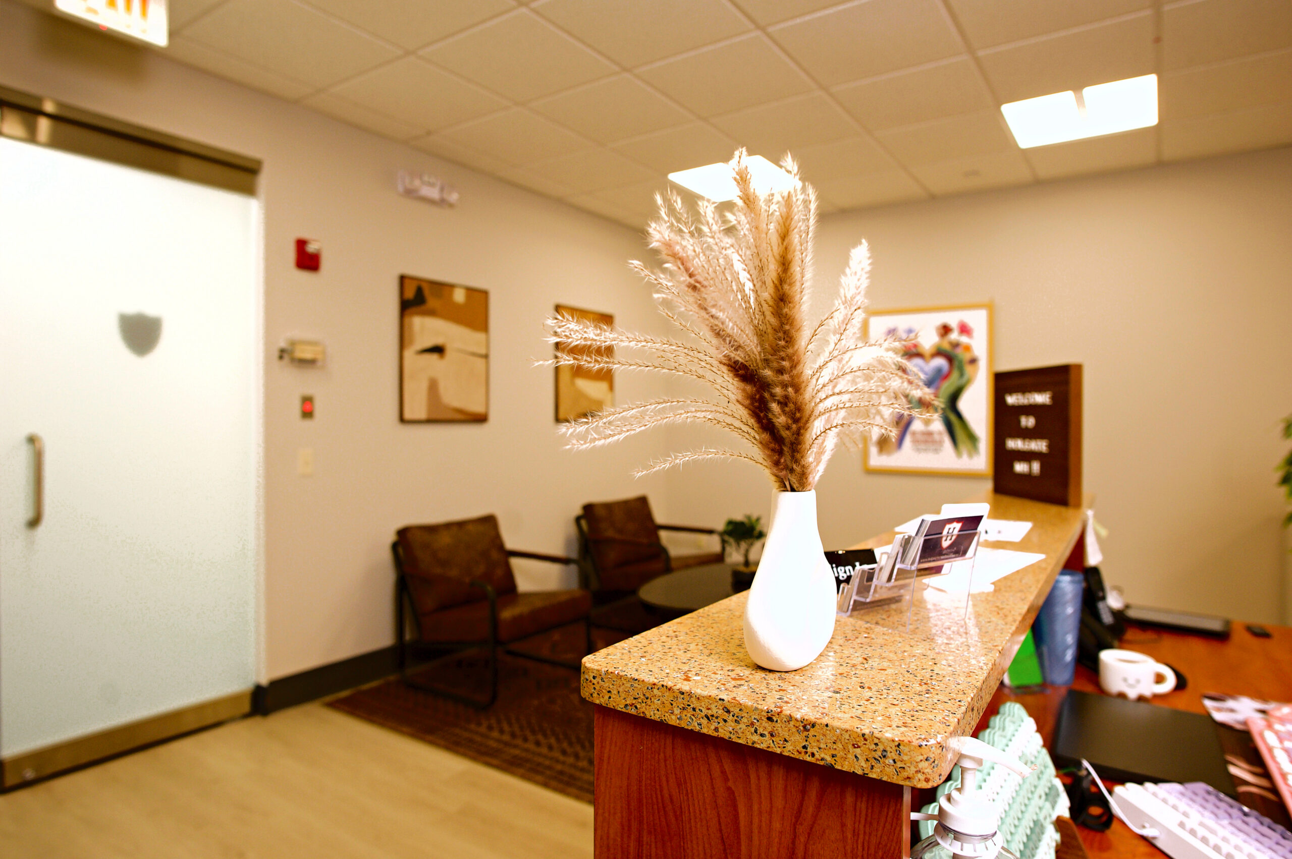 Small waiting area with two chairs, wall art and a pampas grass vase at Holgate Mental Health